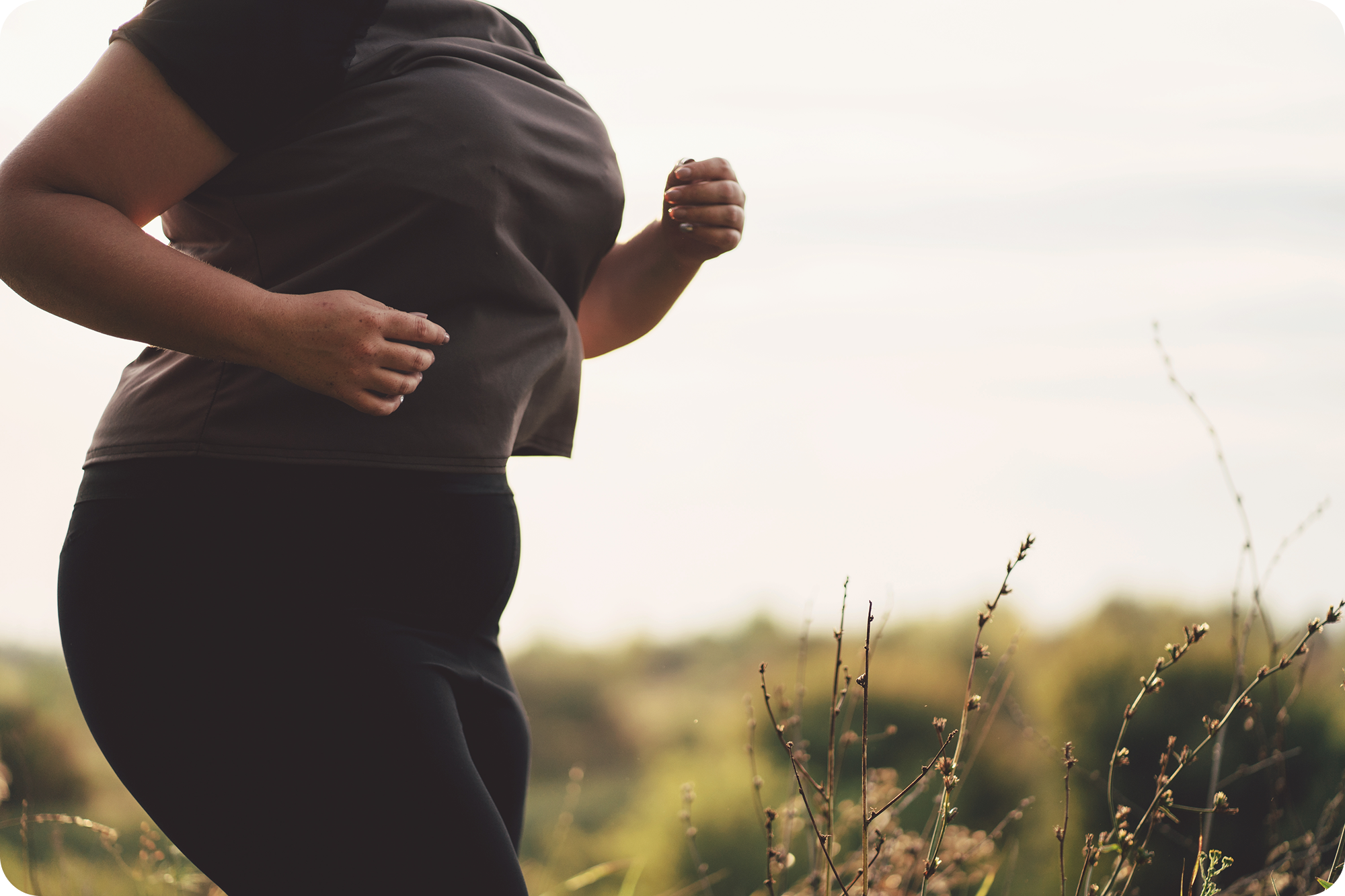 Vrouw jogt buiten in de natuur als onderdeel van een gezonde leefstijl met realistische doelen.